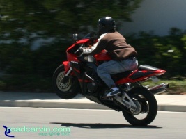 CBR954RR - Wheelie (III): The rider using liter bike horsepower to carry this long wheelie. The black crash cage looks good with the Red/Black color scheme on this 2002 Honda CBR954RR.